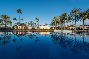 A pool with palm trees and buildings in the background. - HD Parque Cristóbal Gran Canaria (San Bartolomé de Tirajana)