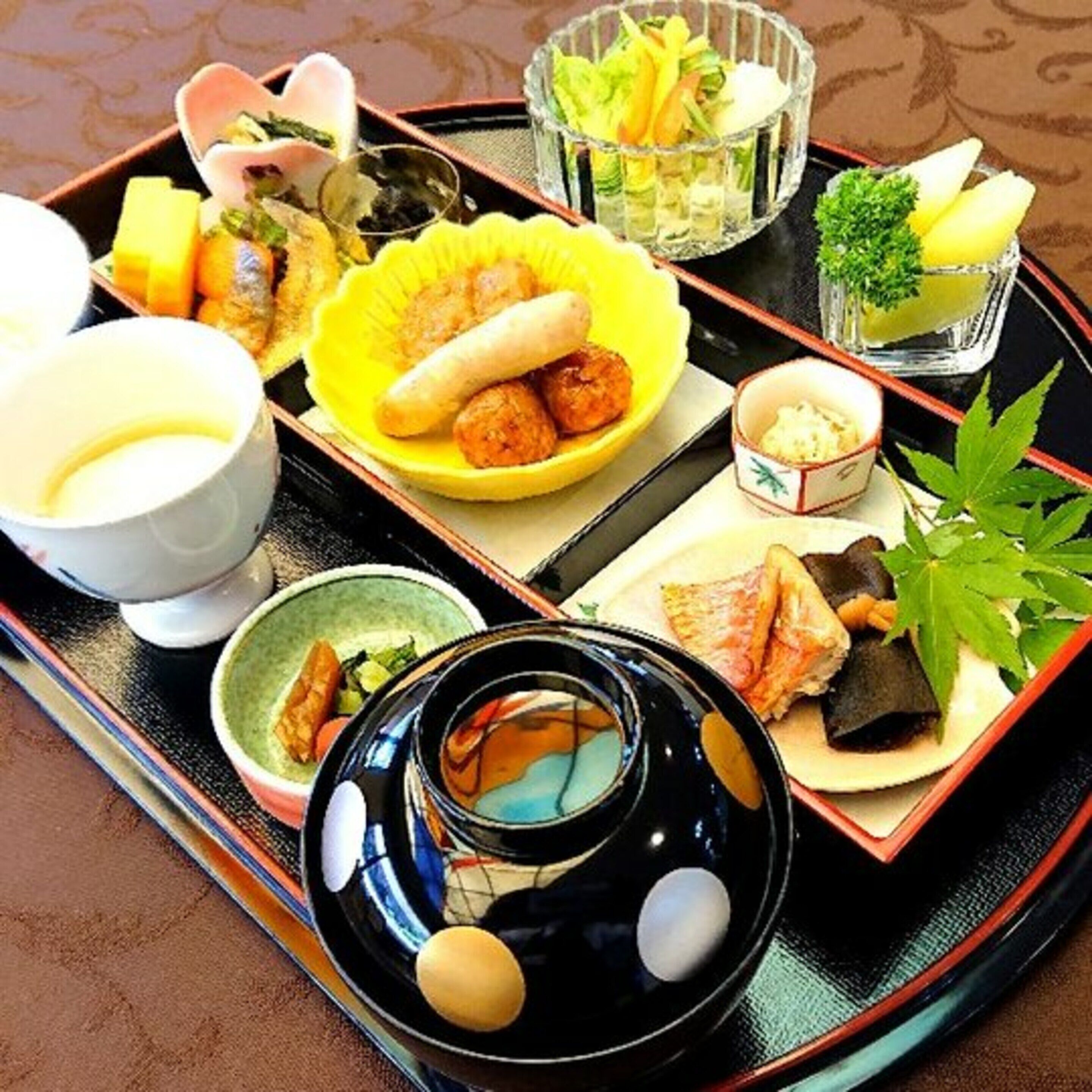 A traditional Japanese meal set on a tray with various dishes including sushi, sashimi, and pickled vegetables.