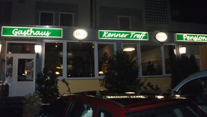 Un edificio con letreros que indican 'Gasthaus', 'Kenner Treff' y 'Pension'.