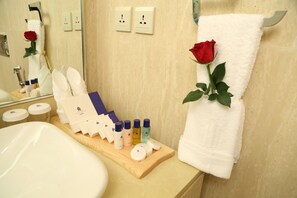 Ein Badezimmer mit Waschbecken, Spiegel und Pflegeartikeln auf einer Holztablett.