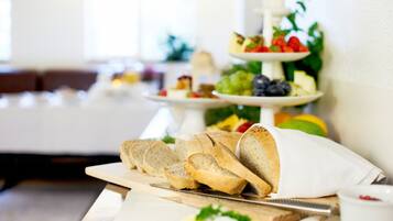 Un bufé de desayuno con diversos alimentos y un cuchillo sobre una tabla de cortar.