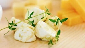 Une table en bois avec du fromage et des herbes.