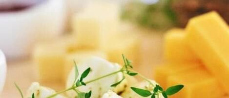 A wooden table with cheese and herbs.