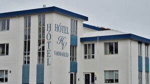Un bâtiment d’hôtel avec une façade blanche et des touches de couleur bleue.