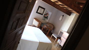 Un dormitorio con cama, una silla, una mesita y un aparador.