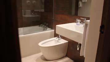 Un bany modern amb una banyera independent, un vàter i un lavabo.
