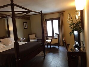 A four-poster bed, a desk, a chair, and a window with curtains. - Hospederia de Cuenca (Cuenca)