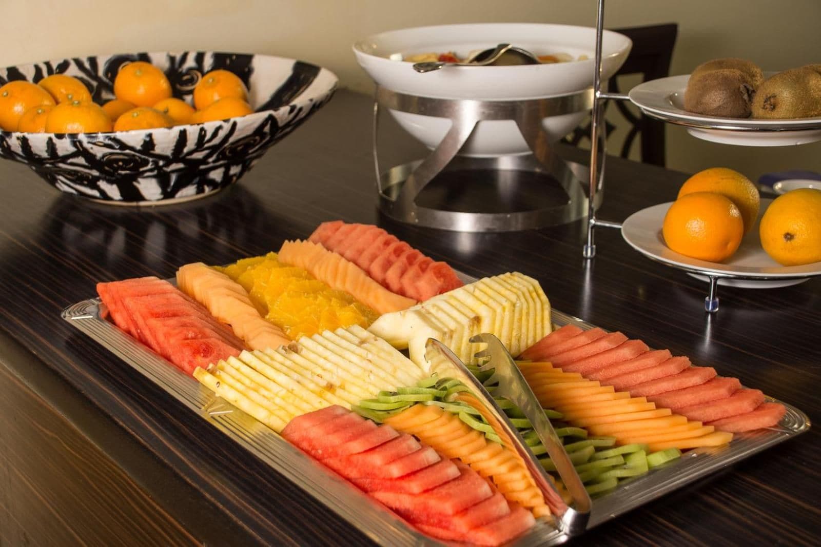 Ein Buffet mit verschiedenen Früchten und Gemüse, ordentlich in Tabletts angerichtet.