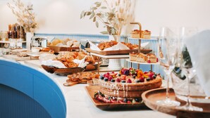 Un bufé con diversos pasteles, tortas y una tarta cubierta de fruta sobre un mostrador.