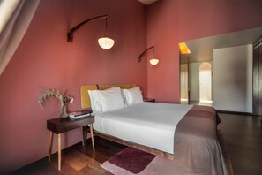 Une chambre à coucher avec un lit, une table de chevet, une lampe et un miroir.