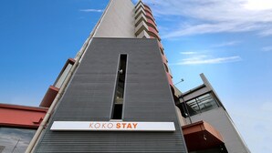 A modern building with a sign reading 'KOKO STAY' at the entrance. - KOKO STAY Sagamihara (Sagamihara)
