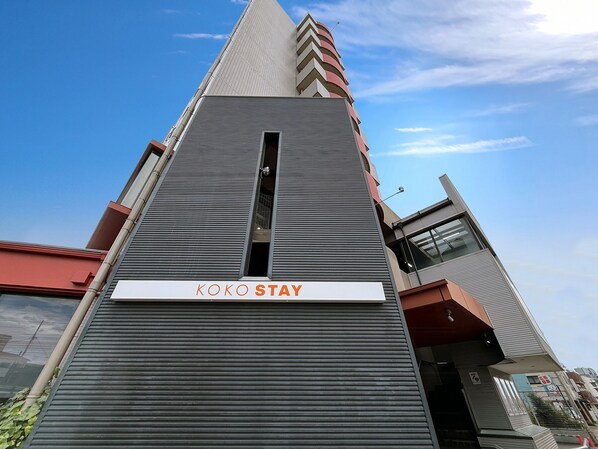 A modern building with a sign reading 'KOKO STAY' at the entrance. - KOKO STAY Sagamihara (Sagamihara)