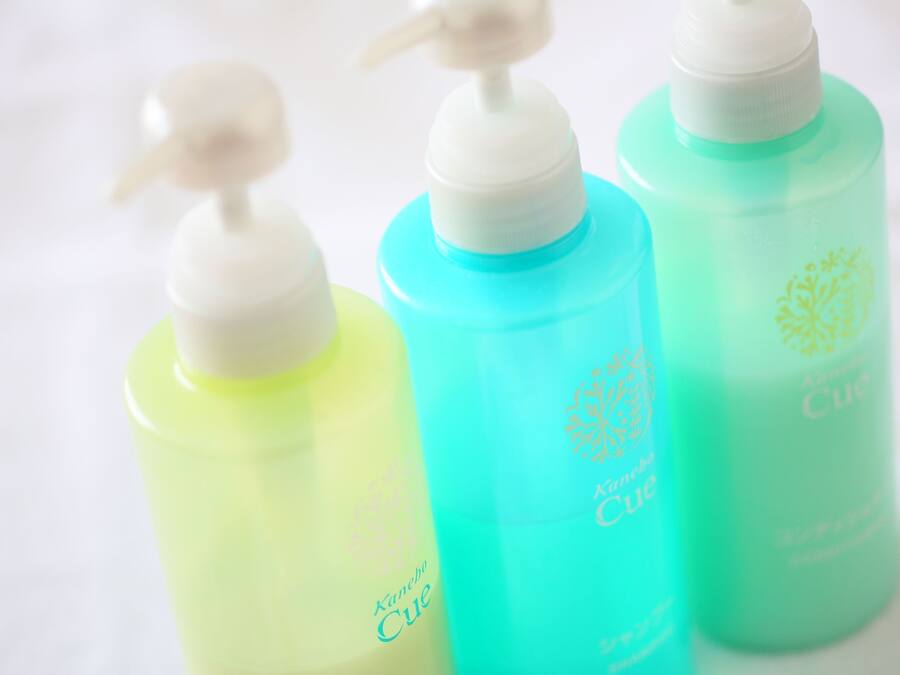 Drei Flaschen Kanebo Cue Shampoo in verschiedenen Farben.