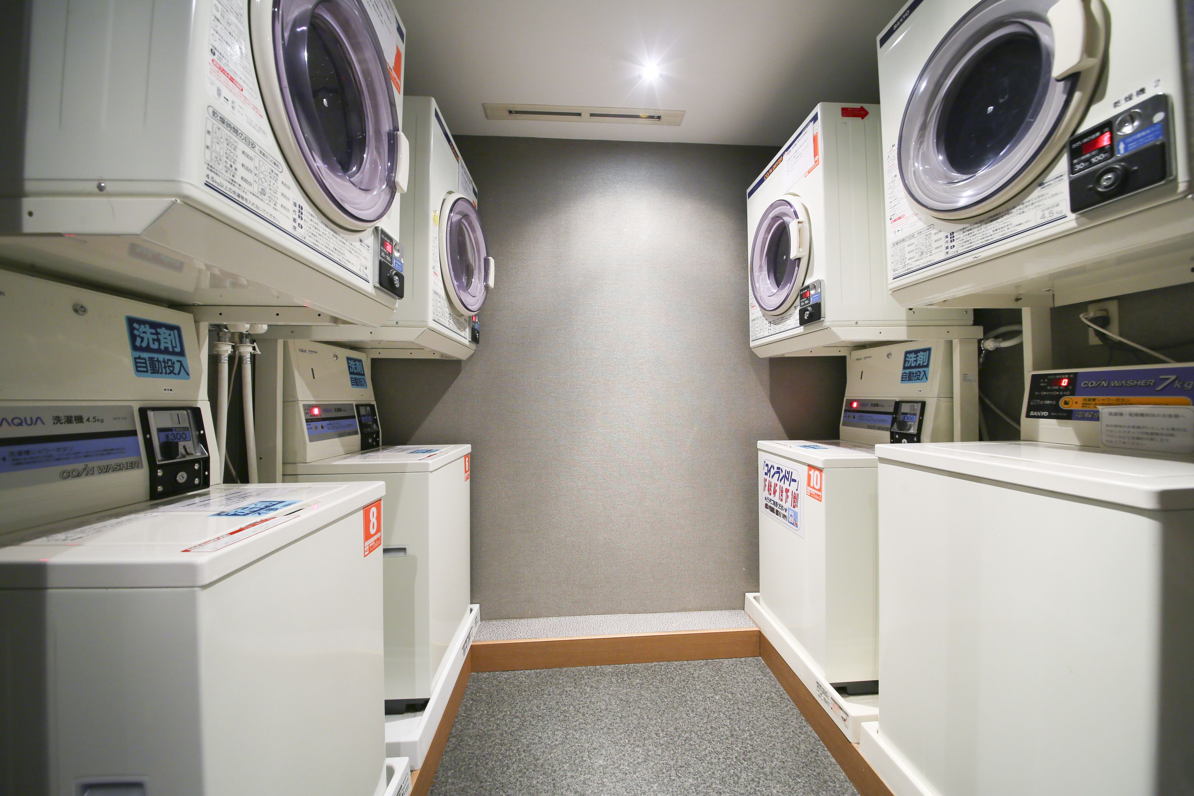 Een wasserette met meerdere wasmachines en drogers.
