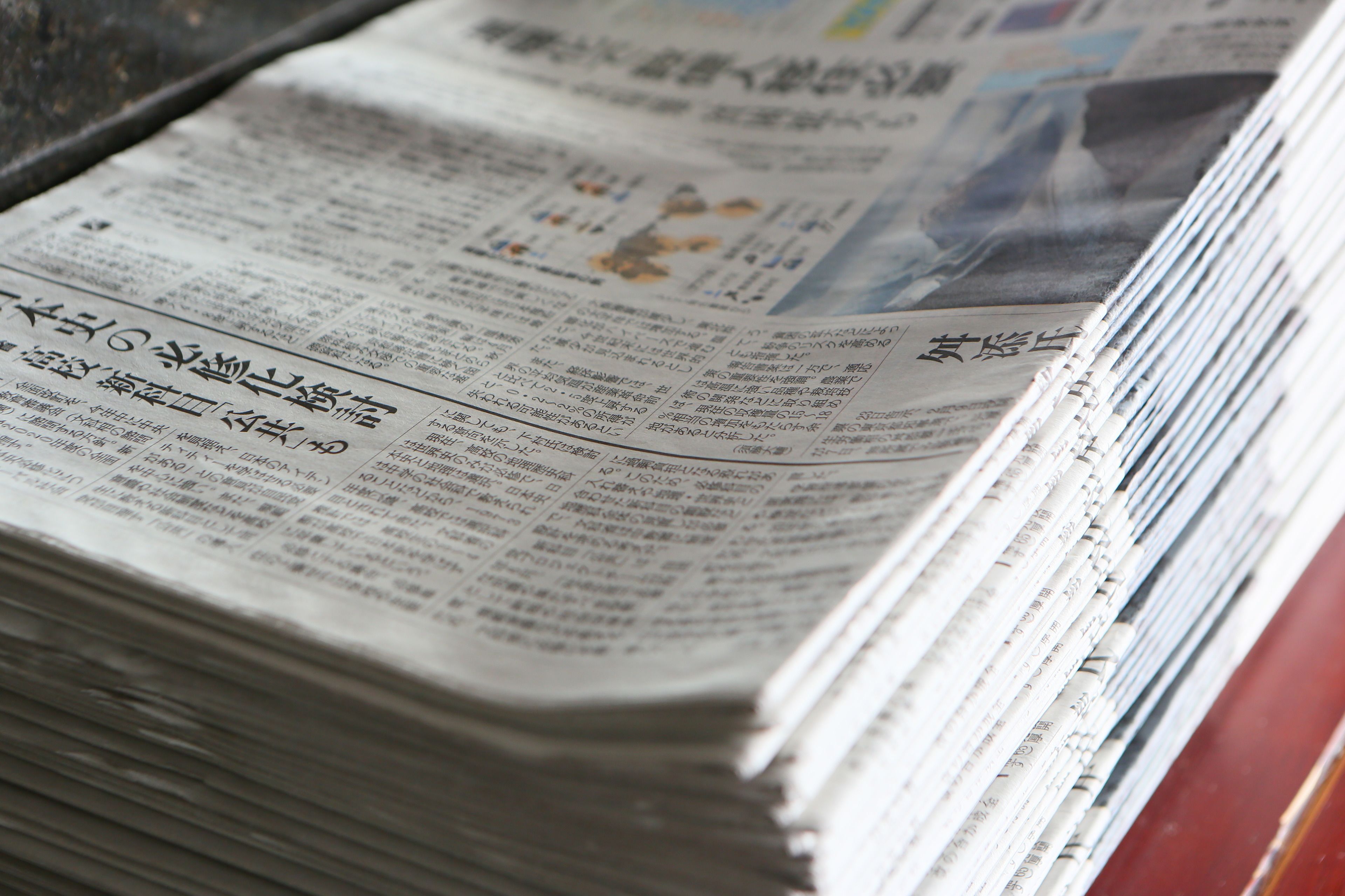A stack of newspapers with text in a foreign language.