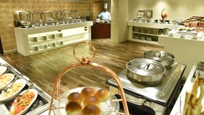 A buffet area with various food stations, including a hot pot and a display of bread rolls. - Royalton Hyderabad (Hyderabad)