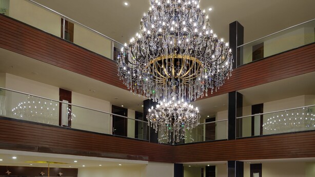 A multi-level lobby with a grand chandelier, seating areas, and a reception desk. - Royalton Hyderabad (Hyderabad)