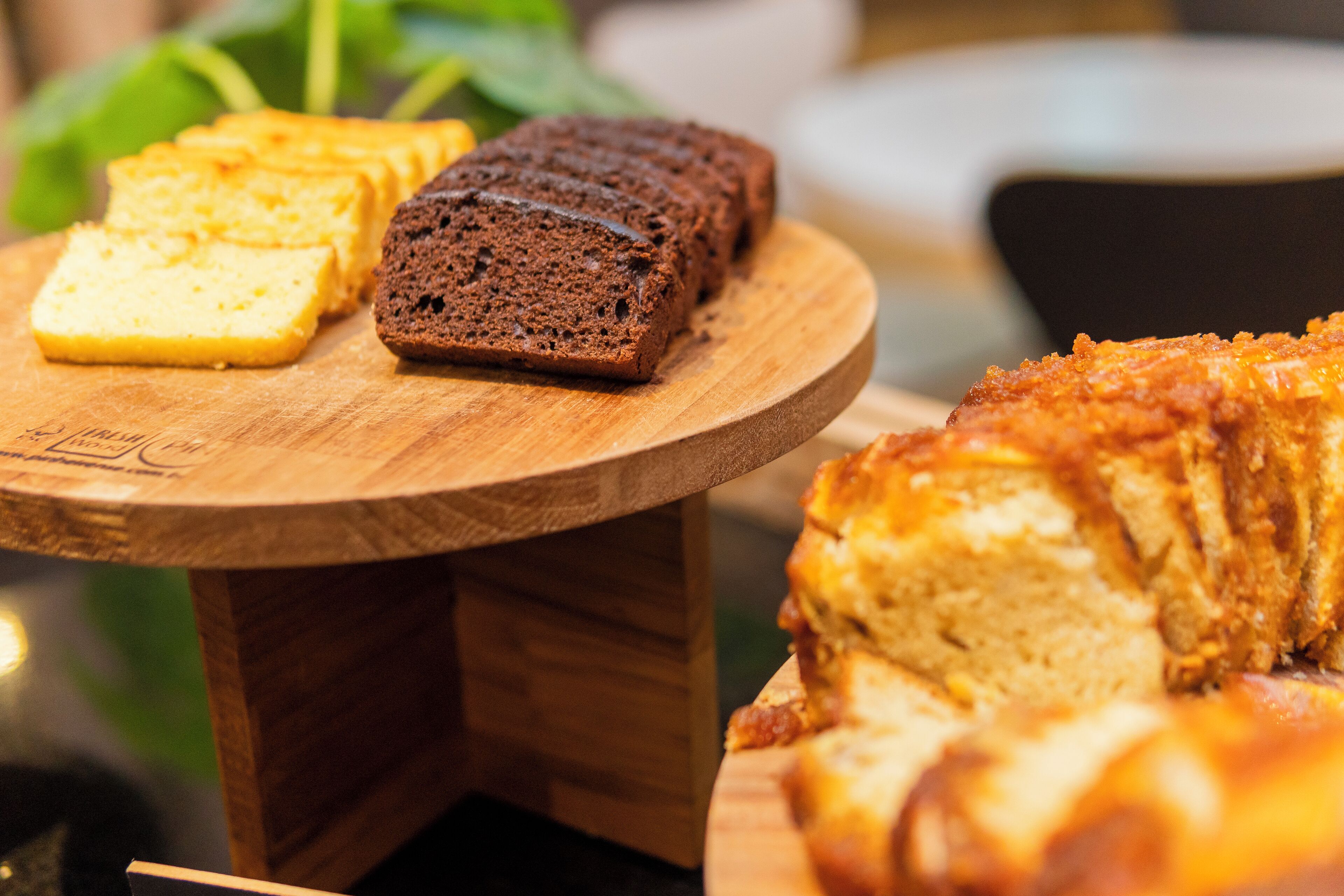 Una mesa de madera con varios tipos de pan, incluyendo un pan con corteza dorada y un pan de color marrón oscuro.