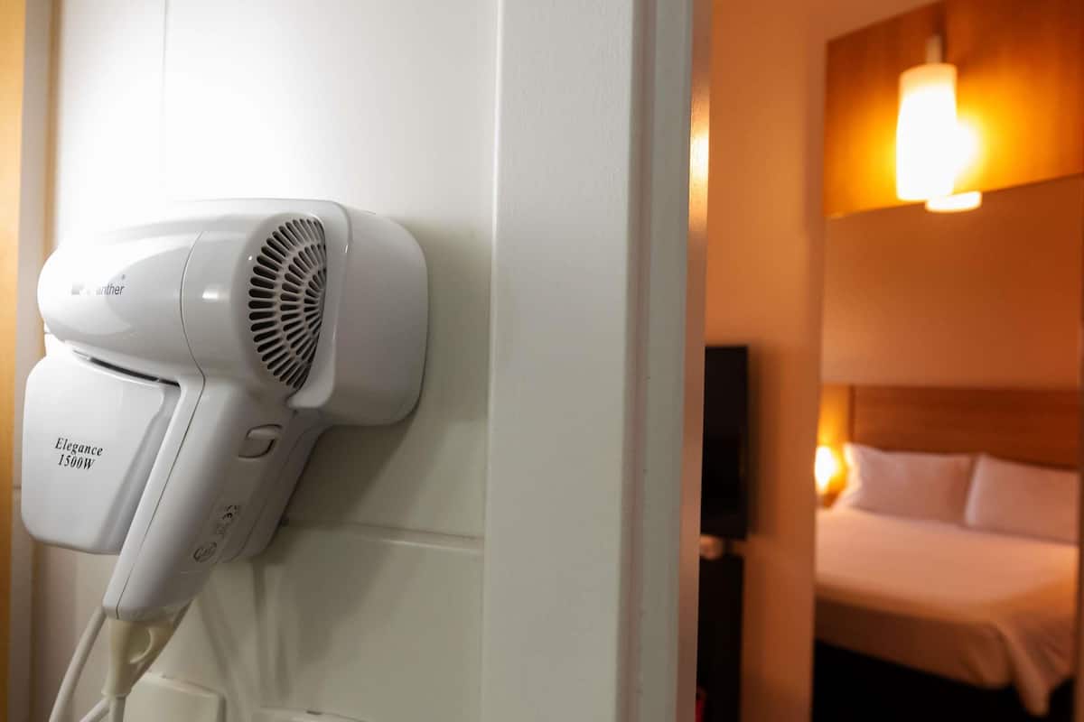 A hair dryer mounted on a wall in a hotel room.