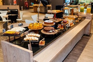 Un bufé con diversos postres y alimentos para el desayuno.