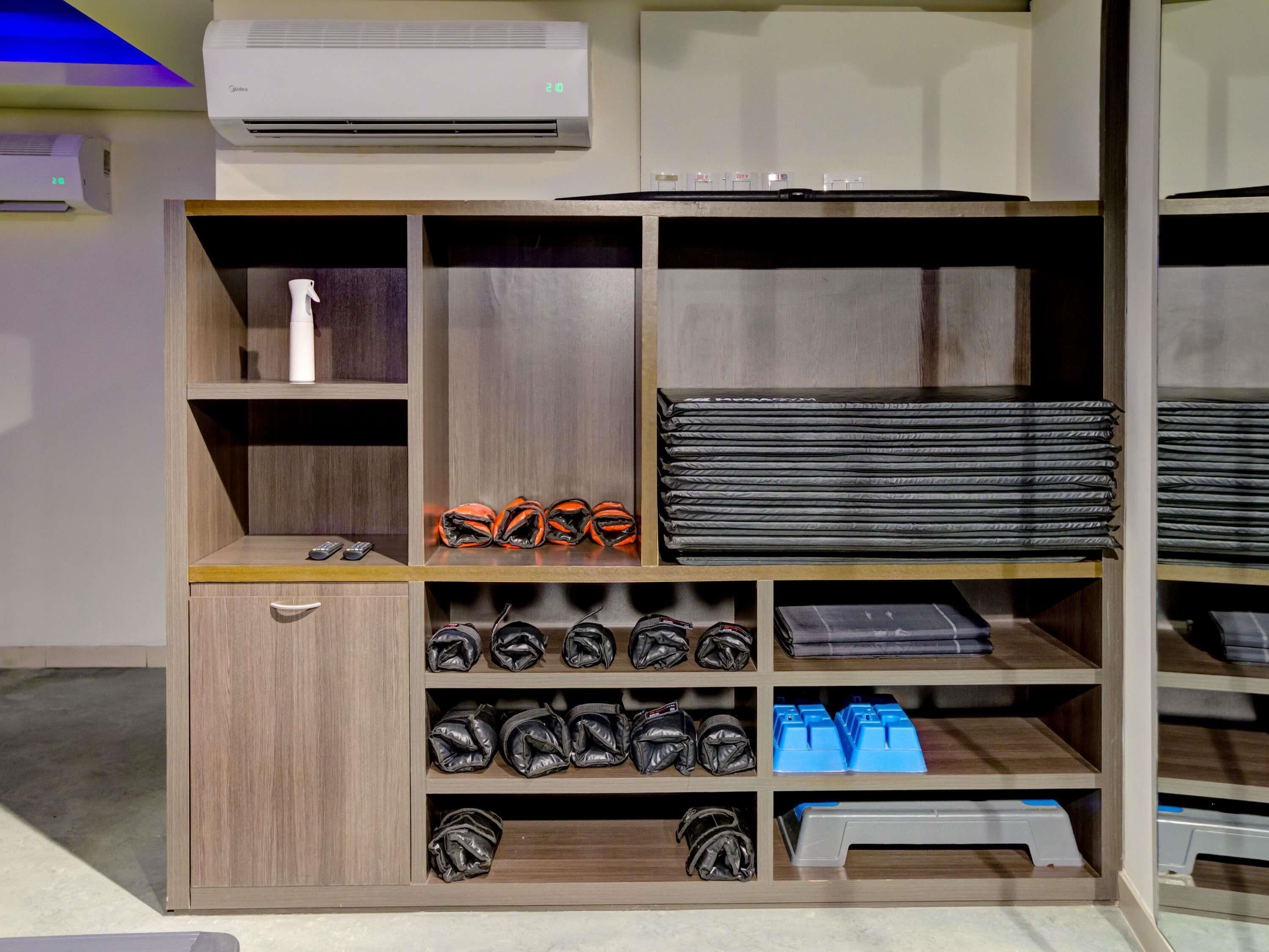 Un depósito con varias estanterías, un mueble bajo y un equipo de aire acondicionado arriba.