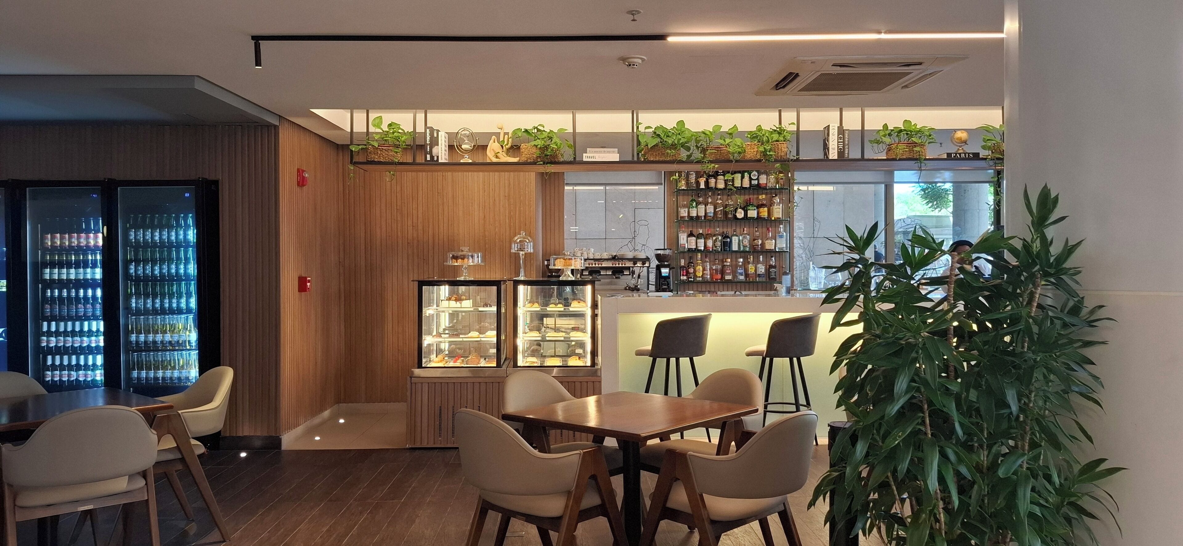 Un restaurante moderno con barra, paneles de madera y diversas opciones de asientos.