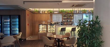Un restaurante moderno con barra, paneles de madera y diversas opciones de asientos.