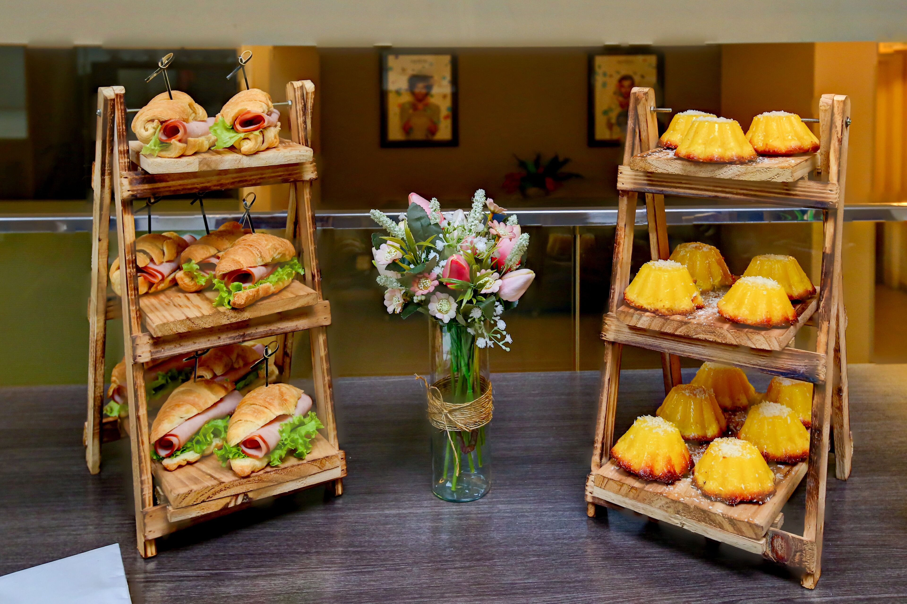 Due espositori di legno con panini e torte rovesciate all'ananas.