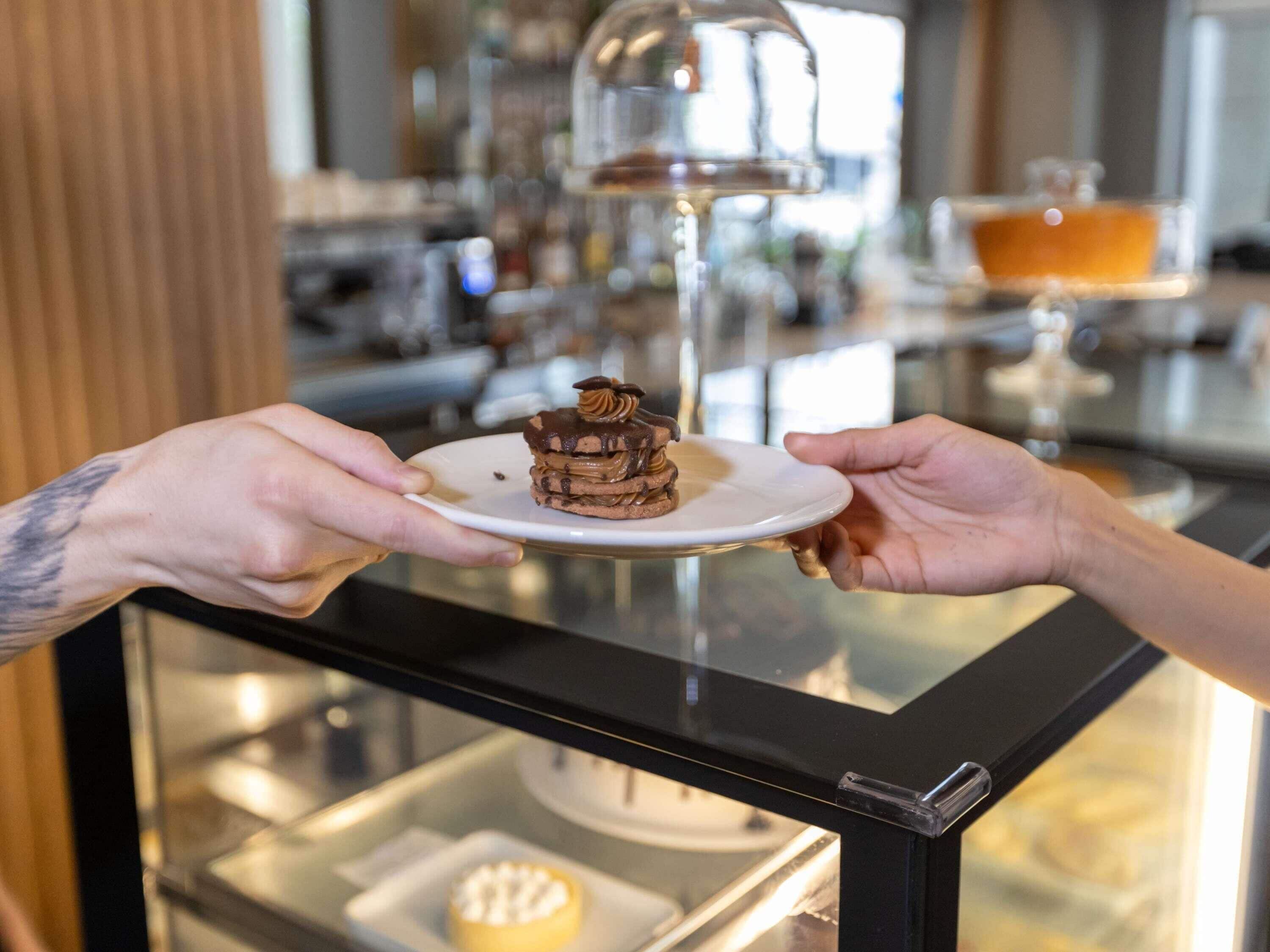 Une personne tenant une assiette sur laquelle se trouve un dessert.