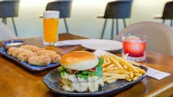 A meal with a burger, fries, and a drink on a table in a restaurant.