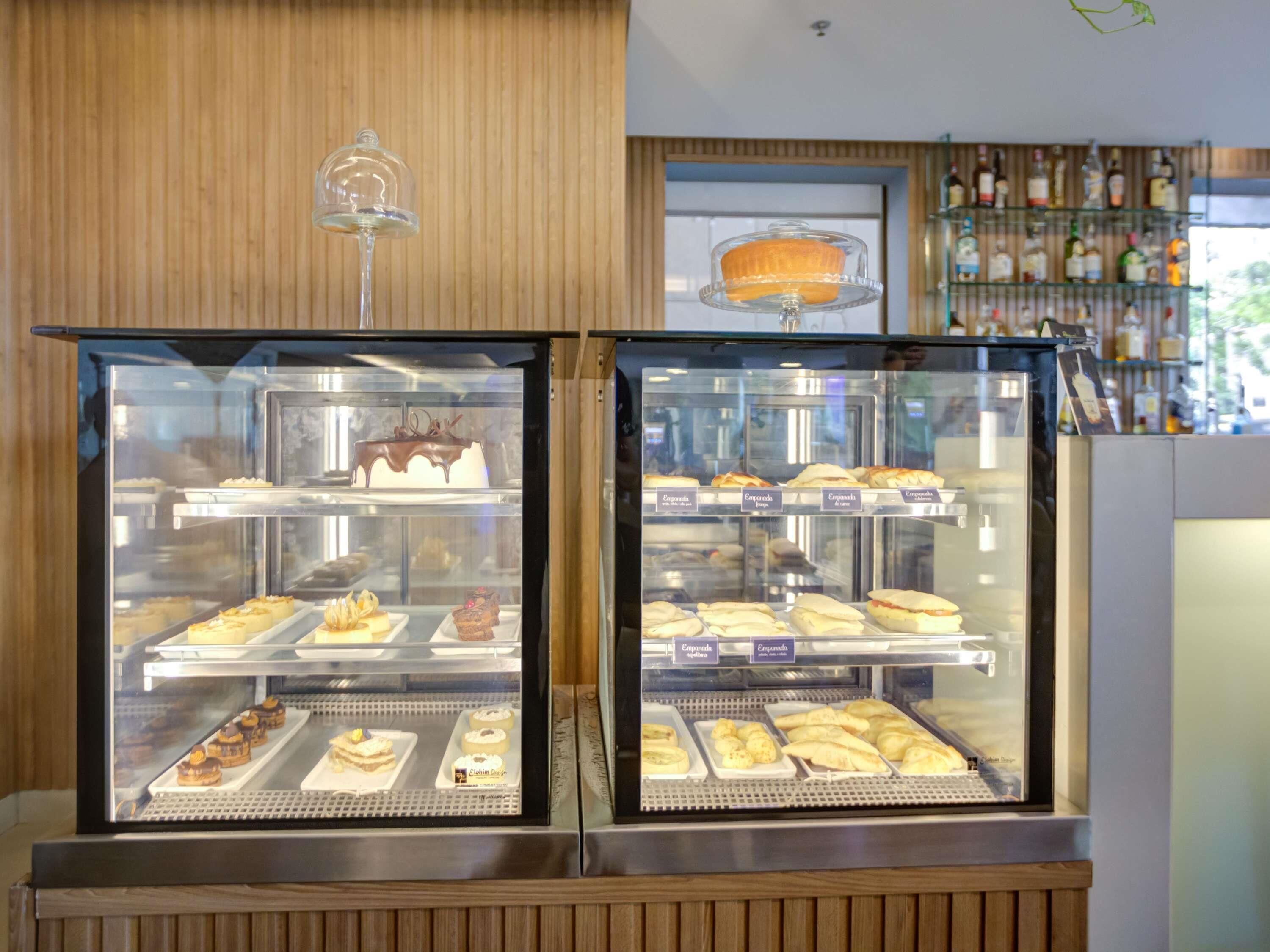 A bakery display case with various baked goods and a cake on top.