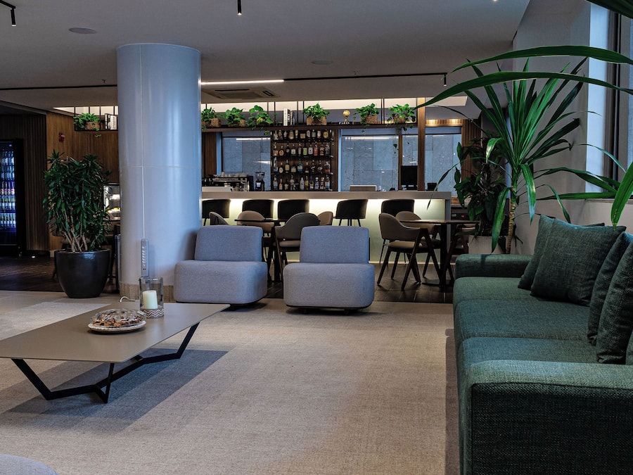 Ett modernt loungeområde med sittplatser, en bar och en stor pelare.