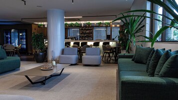 Un espace de détente moderne comprenant des sièges, un bar et une grande colonne.
