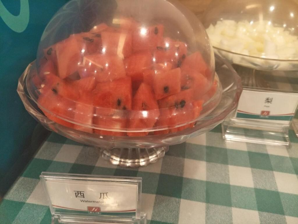 Een buffet met een voorgerecht van watermeloen en een schaal uien.