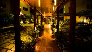 A covered walkway with tiled flooring, surrounded by greenery and columns. - Hotel Bon Voyage (Lagos)