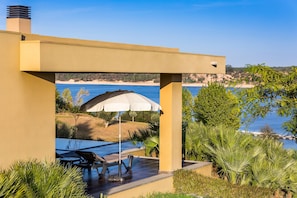 Un patio moderno al aire libre con vista a la playa y al océano.