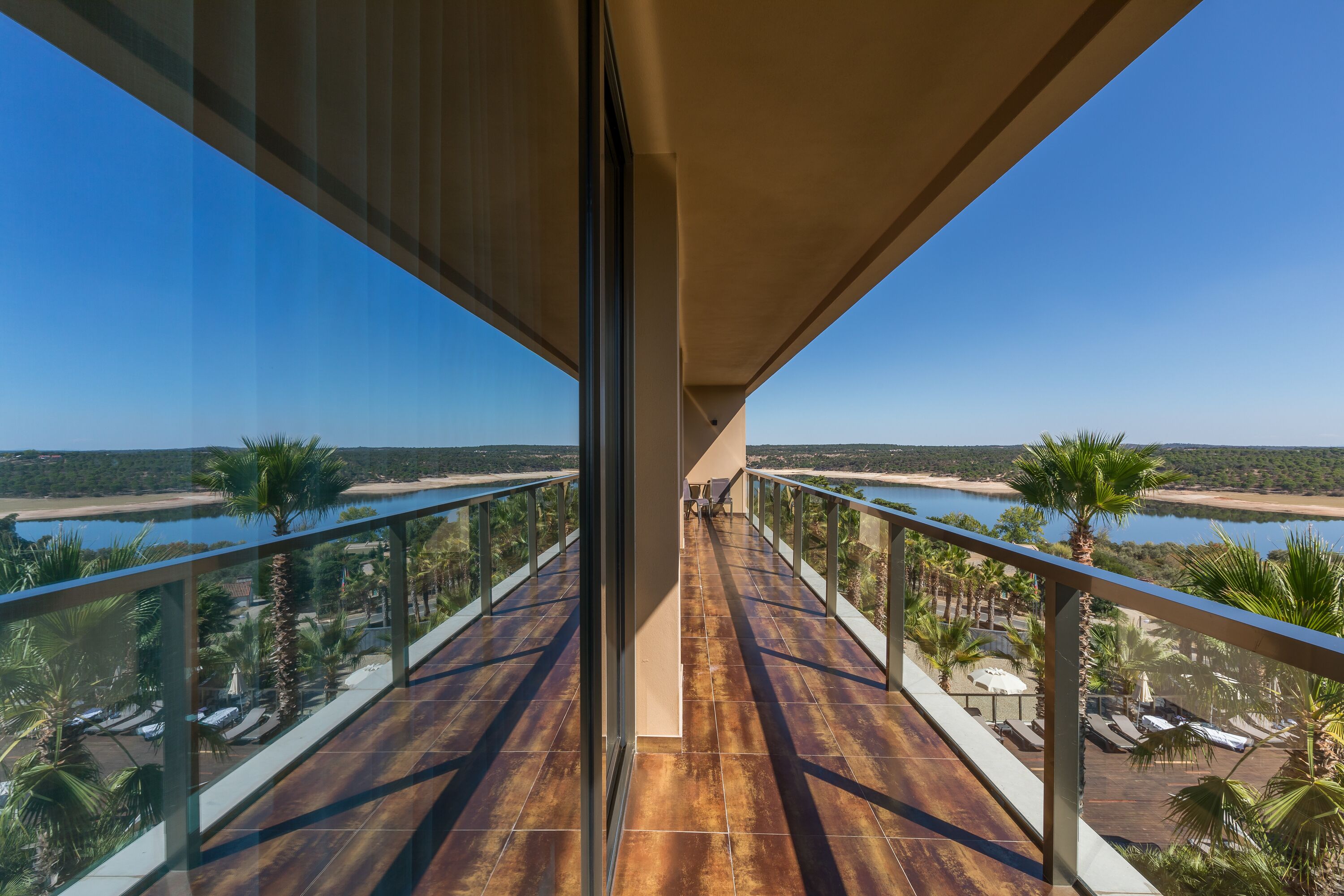 A balcony with a view of a beach and water body.