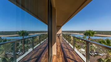A balcony with a view of a beach and water body.
