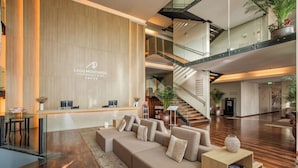A modern lobby with a reception desk, seating area, and a staircase. - AP Lago Montargil Conference & Spa (Ponte de Sor)