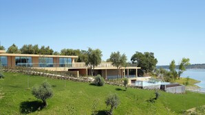 A modern two-story house with large windows, a swimming pool, and a view of the sea. - AP Lago Montargil Conference & Spa (Ponte de Sor)