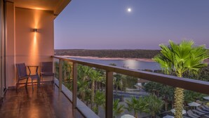A balcony with chairs, a view of the beach, and palm trees. - AP Lago Montargil Conference & Spa (Ponte de Sor)
