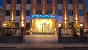 A hotel with a brick facade, a sign reading "HOTEL DINASTIA," and a gated entrance. - Hotel Dinastía (Getafe)
