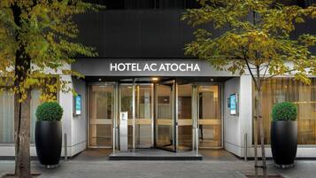 La entrada al HOTEL AC ATTOCHA, con puerta de vidrio y un cartel arriba.