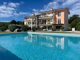 Una piscina al aire libre de temporada, sombrillas
