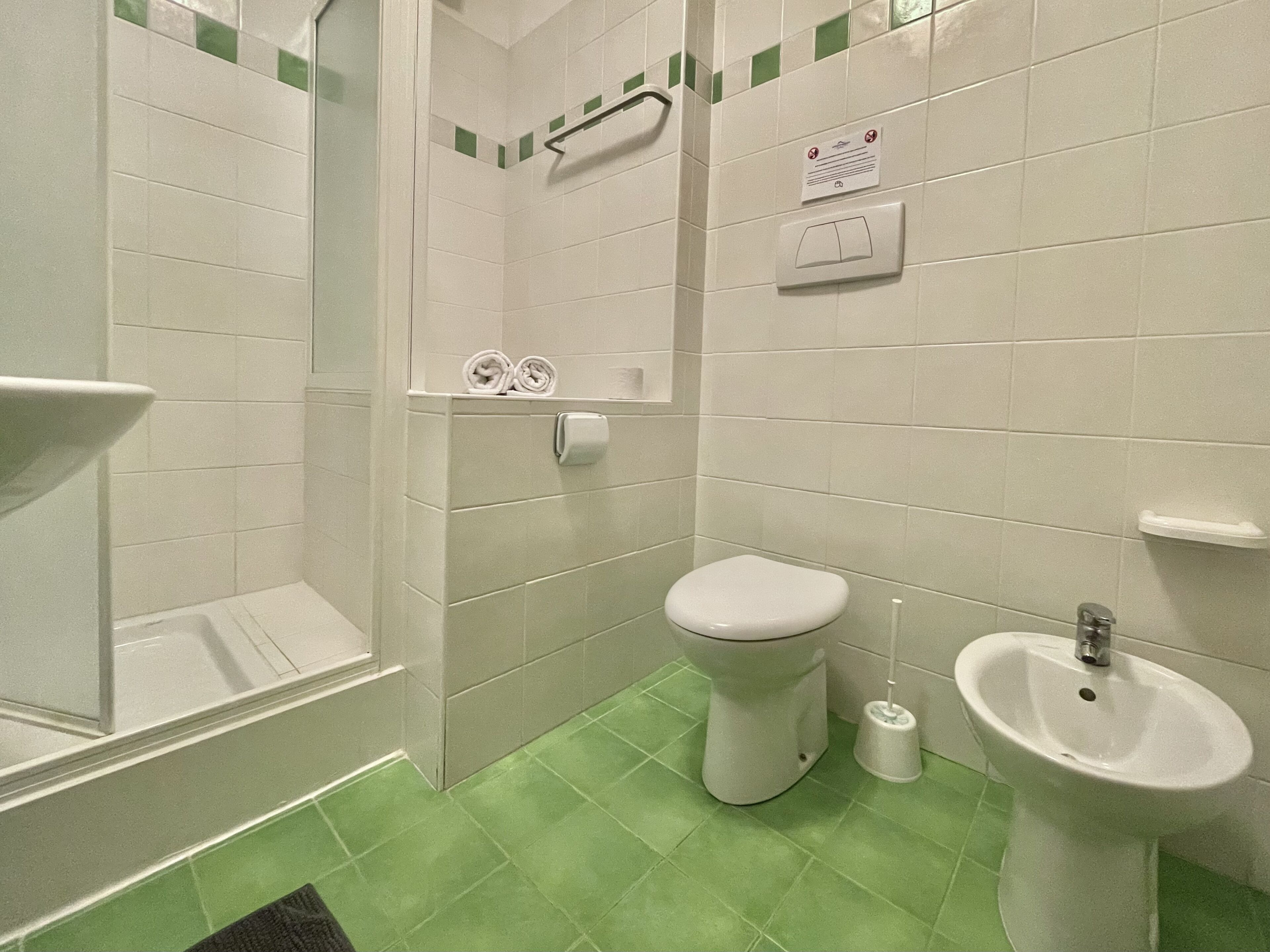 Une salle de bain comprenant des toilettes, un bidet et un espace douche.