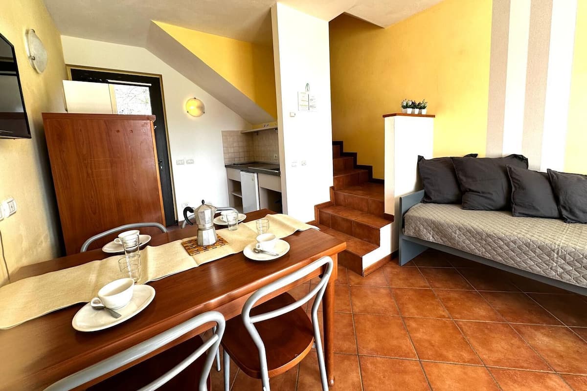 A compact living space with a dining area, kitchenette, and a sofa.