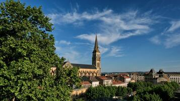 A historic town with a prominent church featuring a tall spire, surrounded by lush greenery and traditional architecture.