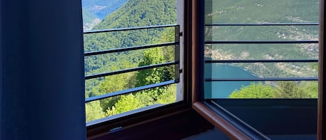 A room with a window overlooking a mountainous landscape.