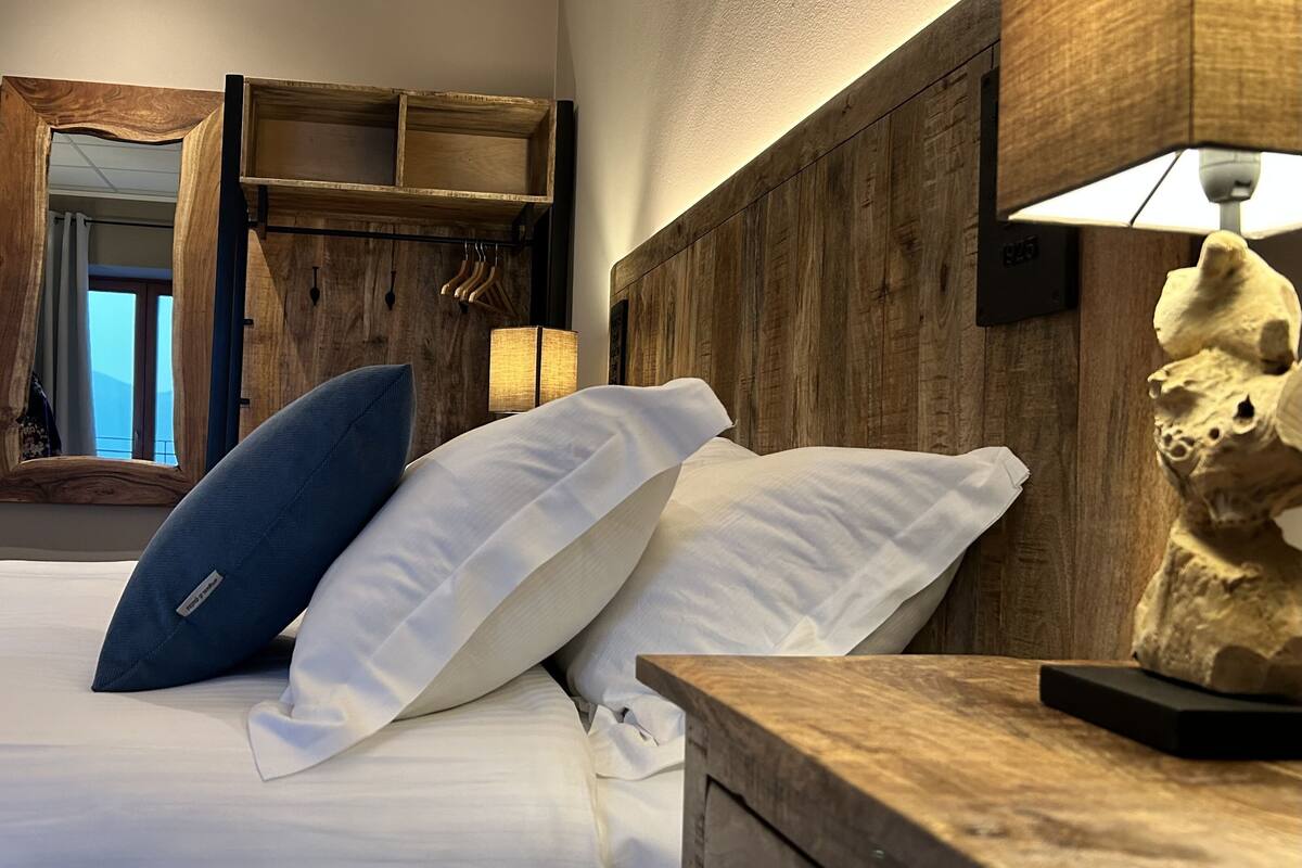 Een slaapkamer met een houten hoofdbord, een bedlampje en een nachtkastje.