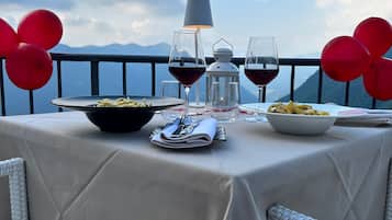 A table set for dining with a view of mountains, red balloons, and a white lantern.